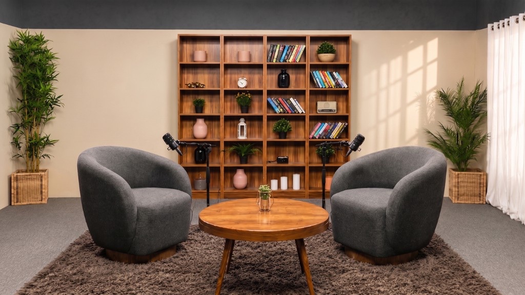 Podcast interview set with grey armchairs, microphones, and bookshelf backdrop at Winterfox Studios